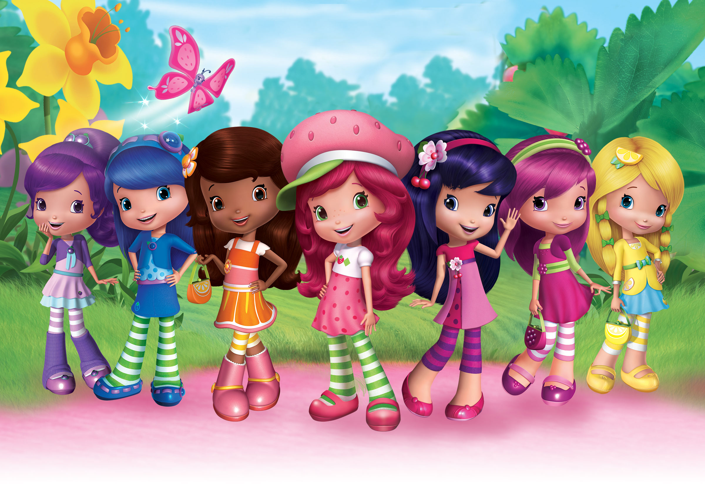 Siete personajes femeninos de dibujos animados, con cabello y ropa de colores brillantes, en un jardín con un arbusto de fresa y grandes flores detrás de ellos.